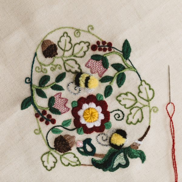 crewel work egg stitched in red, yellow, green, brown and black