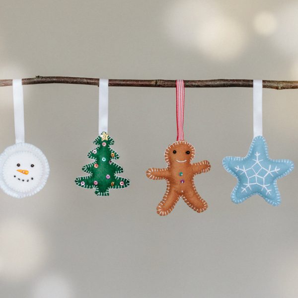 4 felt Christmas decorations, snowman, Christmas tree, gingerbread man and star. hanging from a stick