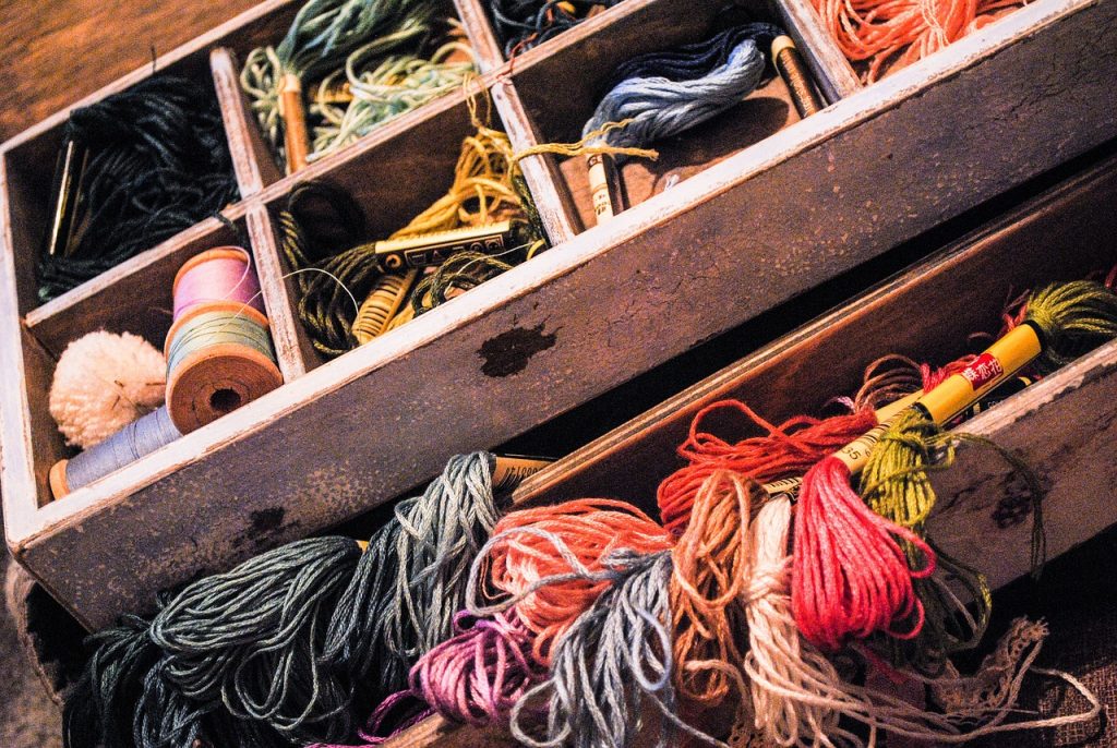 selection of embroidery threads in a wooden storage box